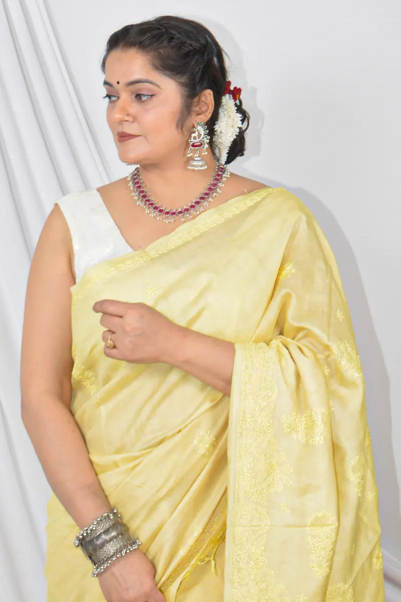 Handcrafted yellow Tussar silk saree with intricate Lucknowi Chikankari embroidery and a matching blouse, ideal for festive and wedding occasions