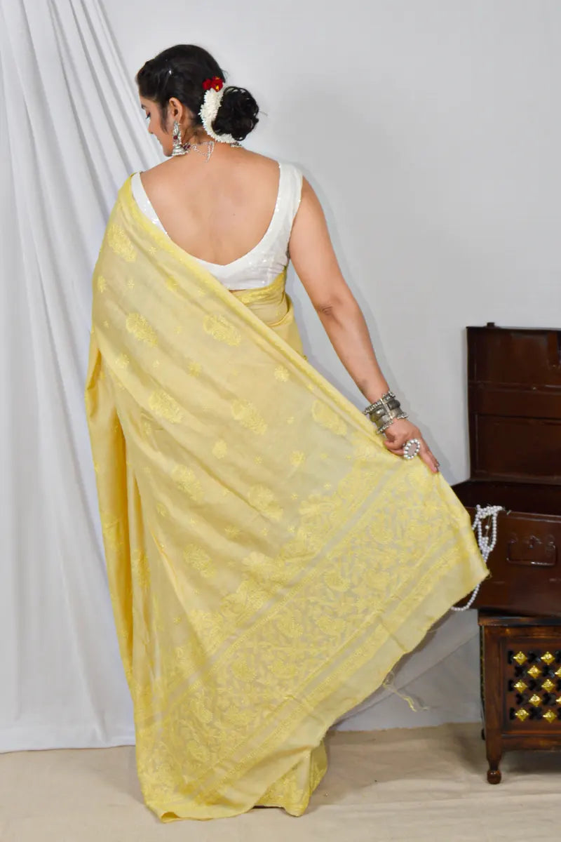 Handcrafted yellow Tussar silk saree with intricate Lucknowi Chikankari embroidery and a matching blouse, ideal for festive and wedding occasions