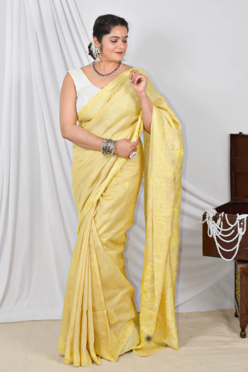 Handcrafted yellow Tussar silk saree with intricate Lucknowi Chikankari embroidery and a matching blouse, ideal for festive and wedding occasions.

