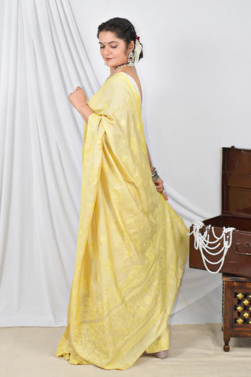 Handcrafted yellow Tussar silk saree with intricate Lucknowi Chikankari embroidery and a matching blouse, ideal for festive and wedding occasions